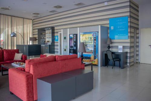 a living room with two red couches and a desk at YIT Vía Sevilla Mairena in Mairena del Aljarafe