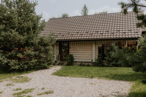a small wooden house with a pathway in front of it at Айворі Хаус in Mykulychyn