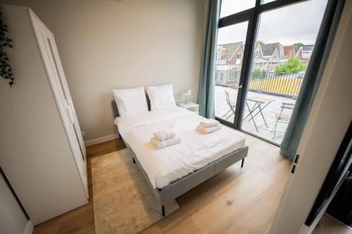 a bedroom with a bed with two towels on it at Ample 3 Bedroom Apartment in Rotterdam