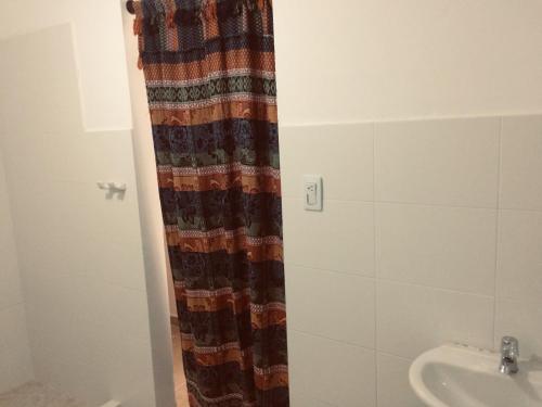 a bathroom with a shower curtain next to a sink at GiGi House Taganga in Taganga