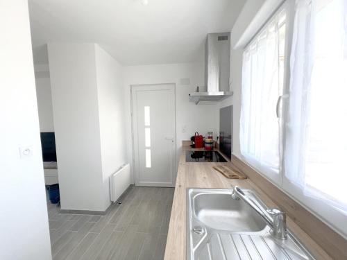 cocina blanca con fregadero y ventana en 180B - Duplex T2 Tout Confort - Wifi Netflix, en Le Gond-Pontouvre