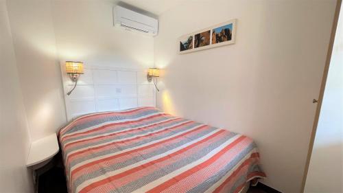 a small bedroom with a bed and two lamps at CosyRefuges - Le Refuge des Goélands in Saint-Raphaël