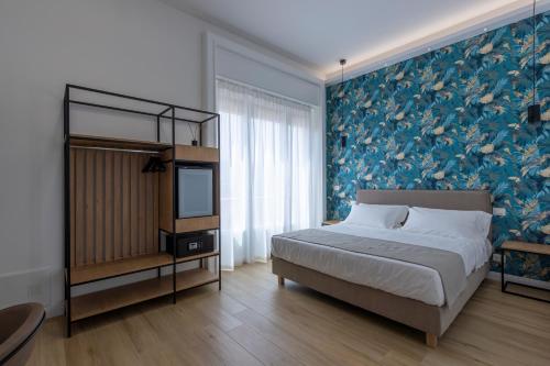 a bedroom with a bed and a blue floral wall at Le Gemme di Cavour Luxury Rooms in Palermo