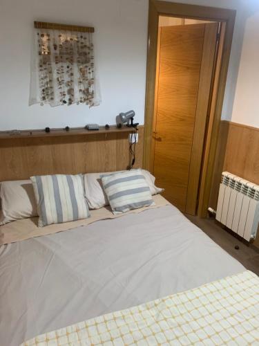 sypialnia z dużym łóżkiem z białą pościelą i poduszkami w obiekcie La Llar de Peramola w mieście Peramola