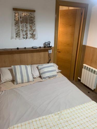 a bedroom with a large bed with white sheets and pillows at La Llar de Peramola in Peramola