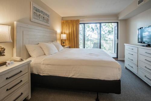 a bedroom with a large bed and a television at Bay Club of Sandestin in Destin