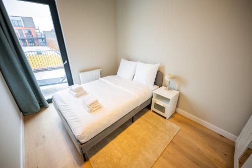 Habitación pequeña con cama y ventana en Breathtaking 3 Bedroom Apartment, en Róterdam