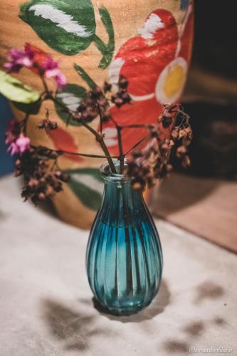a blue vase with flowers and a bird on it at Quintal da Cuiarana - 50M da praia principal de Alter do Chão in Alter do Chao