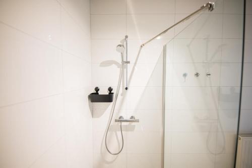 een badkamer met een douche en een glazen deur bij Breathtaking 3 Bedroom Apartment in Rotterdam