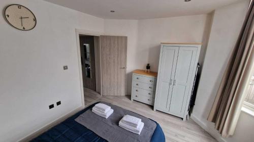 - une chambre avec un lit et une horloge murale dans l'établissement Skyview Strathnairn Apartment 1, à Cardiff