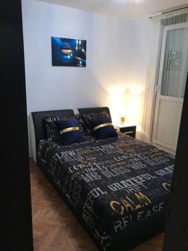 - une chambre avec un lit doté d'une couette et d'oreillers en noir dans l'établissement Apartman/Stan na dan Teslić, à Teslić