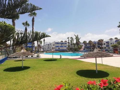 a large swimming pool with umbrellas in a resort at Villa Triplex Palm Beach in Pont Blondin