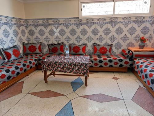 a living room with two couches and a table at Riad Sidi Rahal Beach in Sidi Rahal