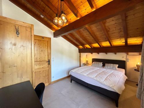 une chambre avec un lit et un plafond en bois dans l'établissement Appartement cosy au centre des Gets, 2 balcons, 2 chambres, proche remontées mécaniques, parking inclus - FR-1-623-297, aux Gets