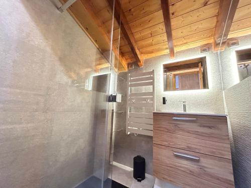 une salle de bain avec douche et lavabo avec un plafond en bois dans l'établissement Appartement cosy au centre des Gets, 2 balcons, 2 chambres, proche remontées mécaniques, parking inclus - FR-1-623-297, aux Gets