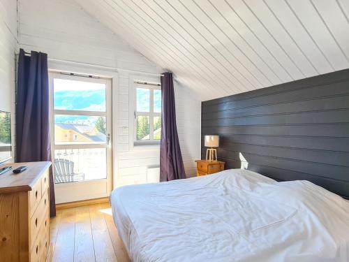 une chambre avec un lit et une grande fenêtre dans l'établissement Chalet spacieux avec poêle à bois, WIFI gratuit, terrasse, garage et proche des pistes - FR-1-425-122, à Flaine