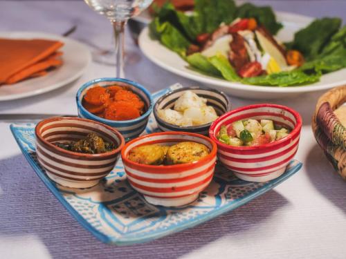 a table topped with bowls of food on a plate at Palais Aix Kabaj &Spa in Marrakech