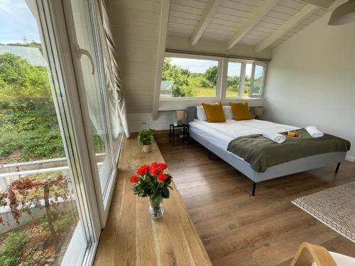 a bedroom with a bed and a large window at Dandelion Szőlőliget Vendégház in Kisapáti