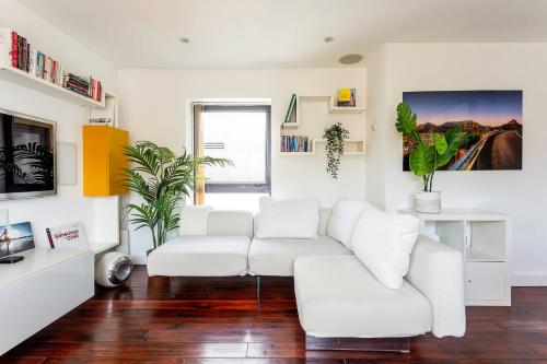 sala de estar con muebles blancos y sofá blanco en Modern Tower Hill Penthouse en Londres