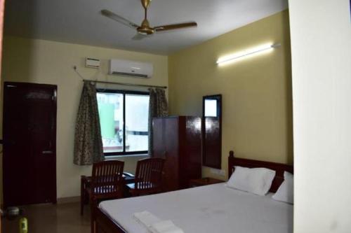 um quarto com uma cama e cadeiras e uma janela em Hotel Lovely Palace ! Puri em Puri