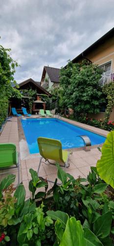 a swimming pool with a green chair next to it at APARTMAN MURKO S-1 