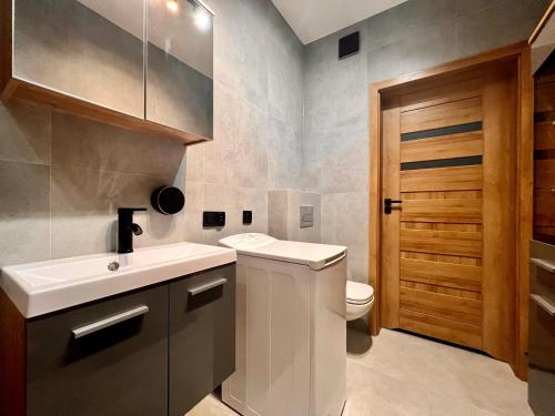 bagno con lavandino bianco e servizi igienici di Apartamenty Drewnowska 77 a Łódź