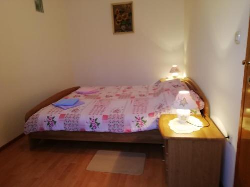 a small bedroom with a bed and a wooden table at Apartmani Vesna in Buje