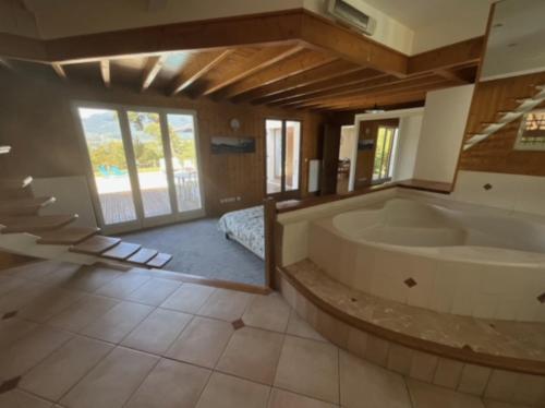 une grande salle de bain avec baignoire et une chambre dans l'établissement Villa avec piscine, vue lac et montagne, à Sévrier