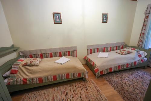 two beds in a small room with at Wenckheim Vadászház in Nagyoroszi