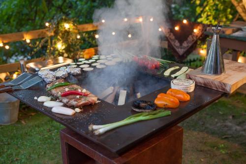 een grill met vlees en groenten op een tafel bij Glamping de Cerveira in Vila Nova de Cerveira