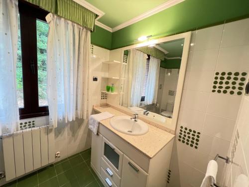 bagno con lavandino e specchio di BAKIO BIDEA BOUTIQUE a Mungia