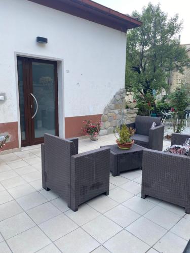 a patio with wicker chairs and a table at B&B La Panoramica in Castelmezzano