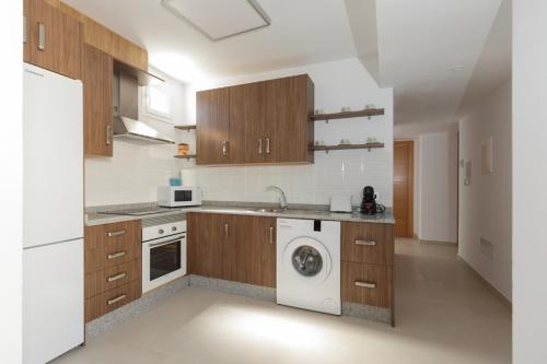 uma cozinha com uma máquina de lavar roupa e uma máquina de lavar roupa em apartamentos El-Hizan em Laujar de Andarax