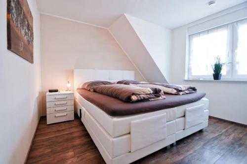 ein Schlafzimmer mit einem Bett in einem Zimmer mit einer Treppe in der Unterkunft Strandbox & Strandresidenz in Norderney