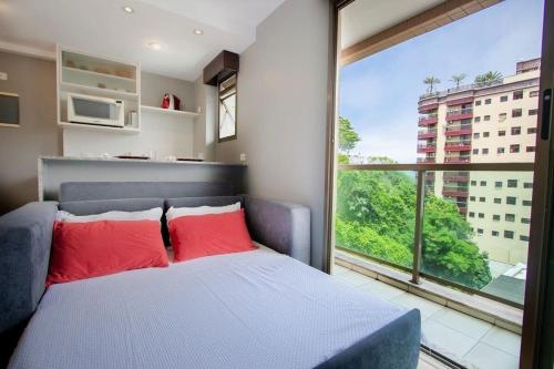 a bedroom with a bed and a large window at Flat Praia de Copacabana Ipanema - Pé na Areia in Rio de Janeiro