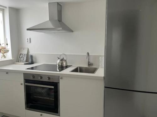 cocina con fregadero y nevera en Boende nära centrum och natur en Gotemburgo