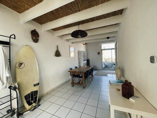une chambre avec une planche de surf et une chambre avec une table dans l'établissement Lovely duplex - 50m fr. the sea, à Lacanau-Océan