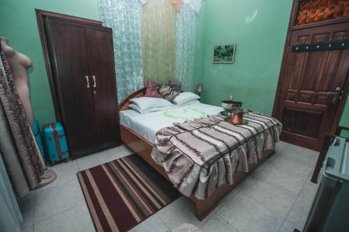 a small bedroom with a bed and a table at Jesiwa B's Little Palace in Accra