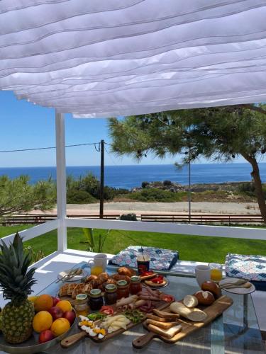 a table with food on it with a view of the ocean at Kallithea Residence in Koskinou
