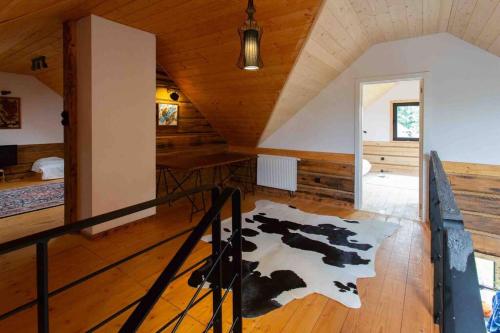 a room with a cow rug on a wooden floor at Grand Rozbój House Beskid Niski, Spa Ogrodowe 