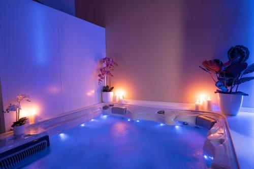 uma banheira de hidromassagem com luzes num quarto com plantas em GG8 Hotel & Suite SPA em Gualdo Tadino