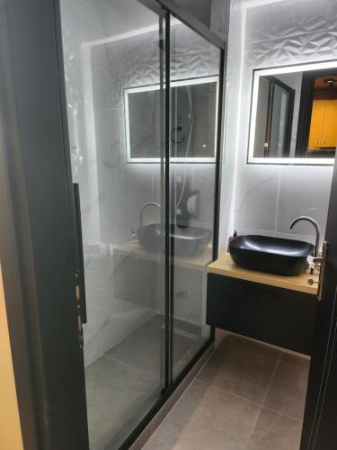 een badkamer met een zwarte wastafel en een spiegel bij Kastello in Meyisti