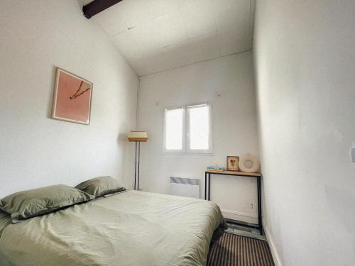 une petite chambre avec un lit et une fenêtre dans l'établissement Lovely duplex - 50m fr. the sea, à Lacanau-Océan