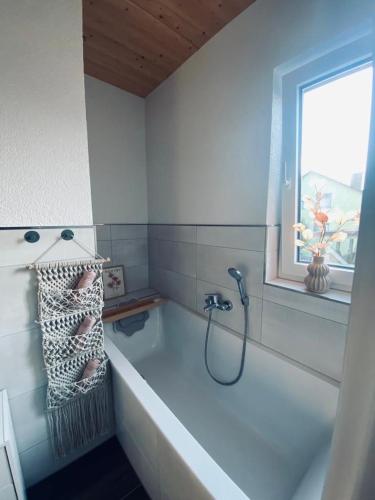 Zimmer m. eigenem Bad und Badewanne direkt am Wald في Amöneburg: حمام مع حوض استحمام ونافذة