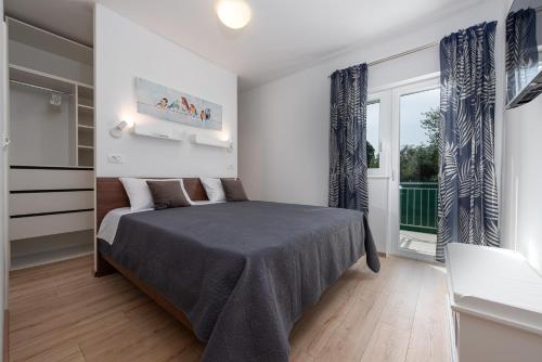 a bedroom with a bed and a large window at Villa Golubica in Sukošan