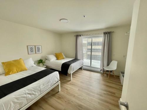 una camera da letto con due letti e una finestra di APPART-HOTEL L'UNI a Québec
