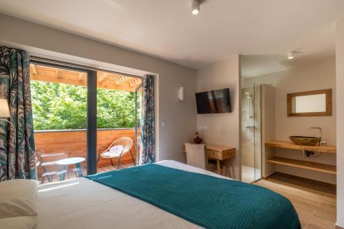 1 dormitorio con cama, ventana y escritorio en Logis Hôtel Les Vieilles Granges, en Granges-Les-Beaumont