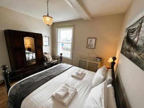 a bedroom with a bed with two towels on it at Chic Listed House with Harbour and River Views in Central Cowes - Walk to top restaurants in East Cowes