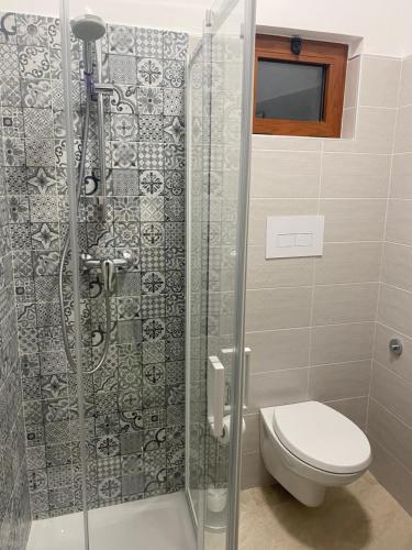 a bathroom with a toilet and a glass shower at B&B La Panoramica in Castelmezzano