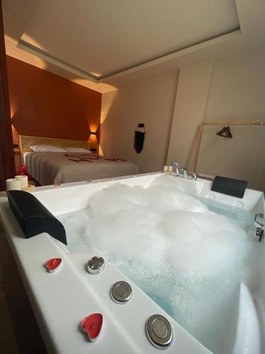 a bath tub filled with water in a room with a bed at Green Hill Apart in Ardeşen